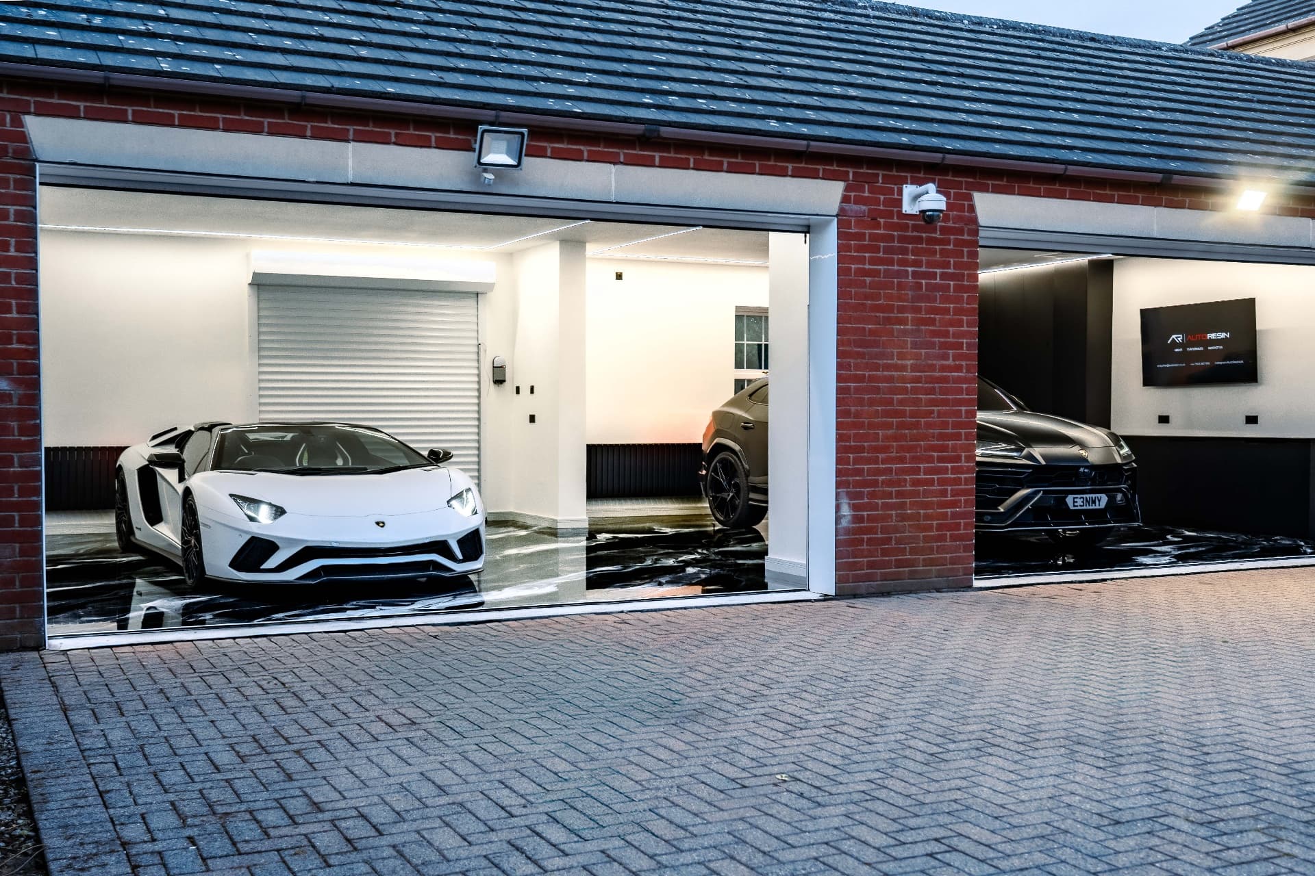 AutoResin garage project with luxury vehicles and glossy resin floor finish