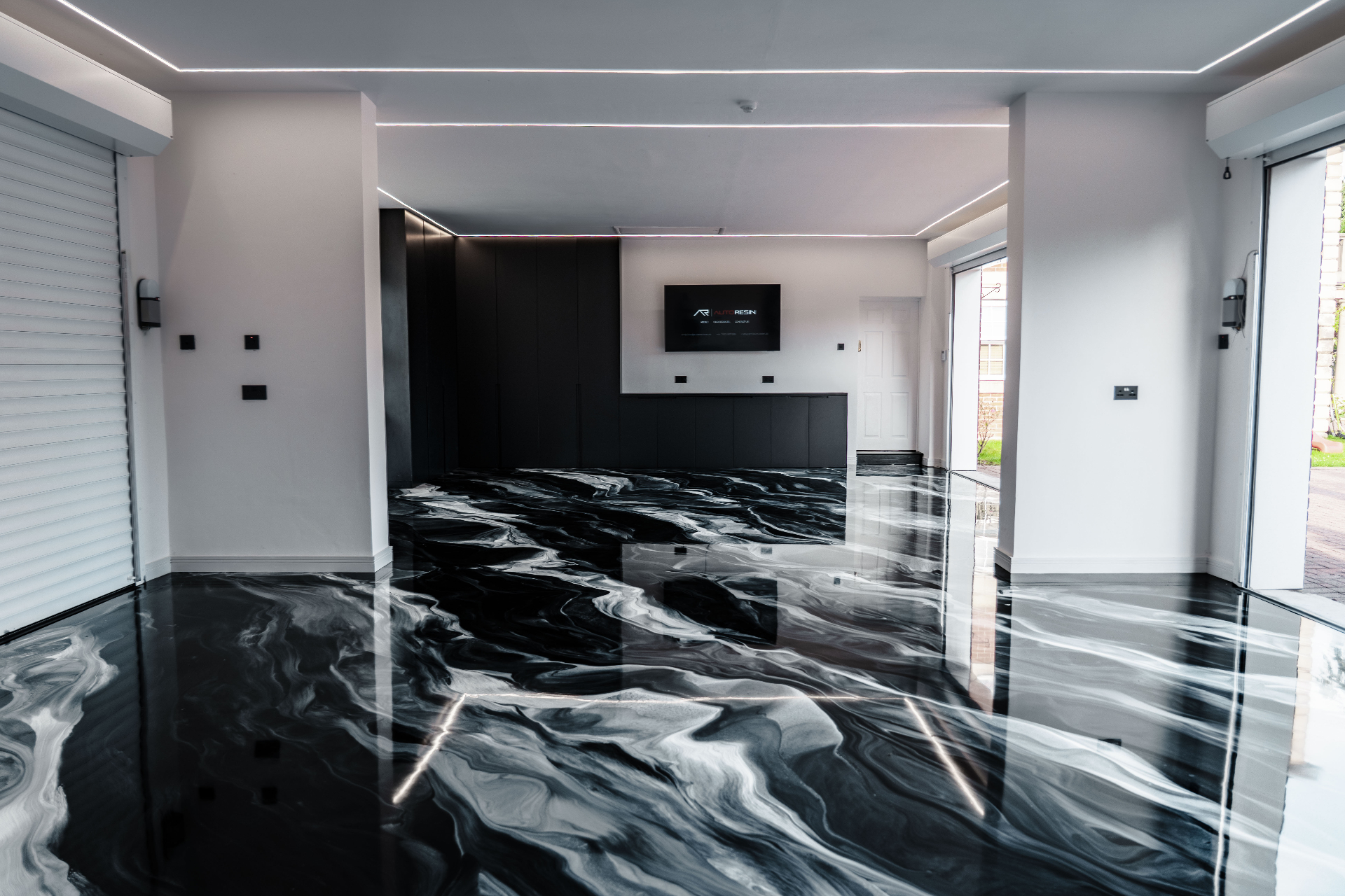 black metallic Auto Marble resin floor in contemporary open-plan living space with LED strip lighting