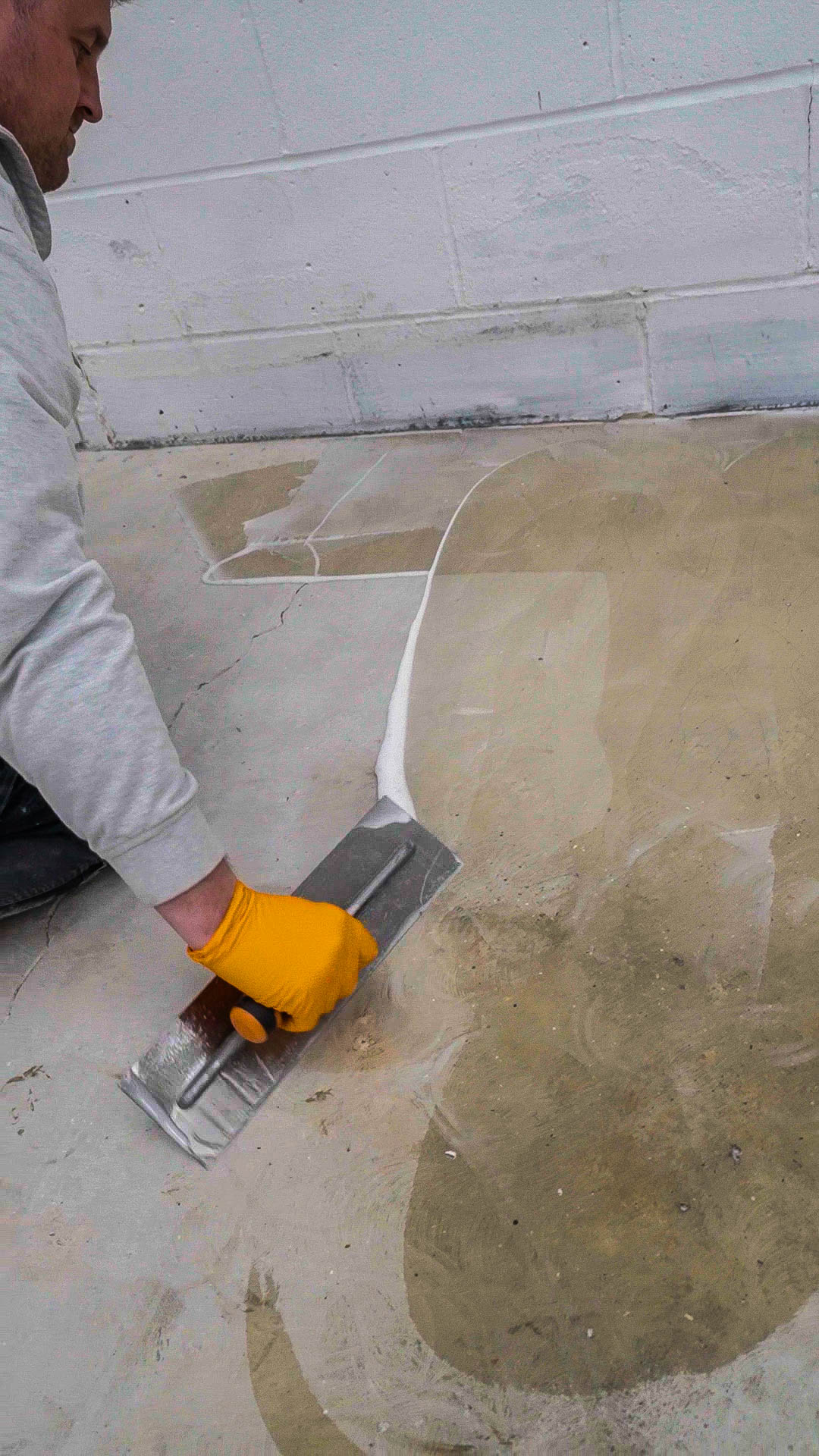 repairing concrete floor cracks with trowel and filler before resin coating