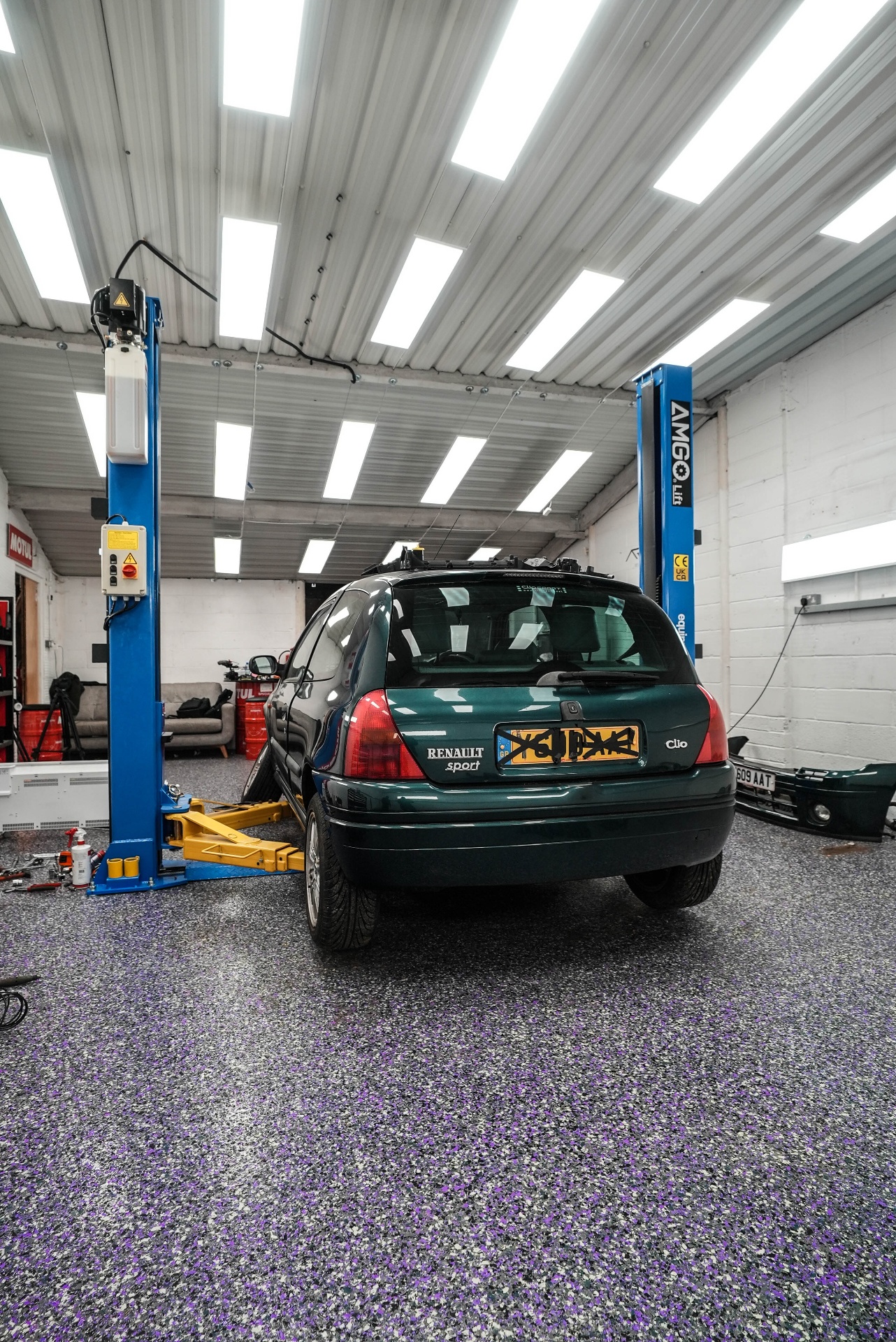 rear angle of Auto Flake resin garage floor with car on lift and tool storage