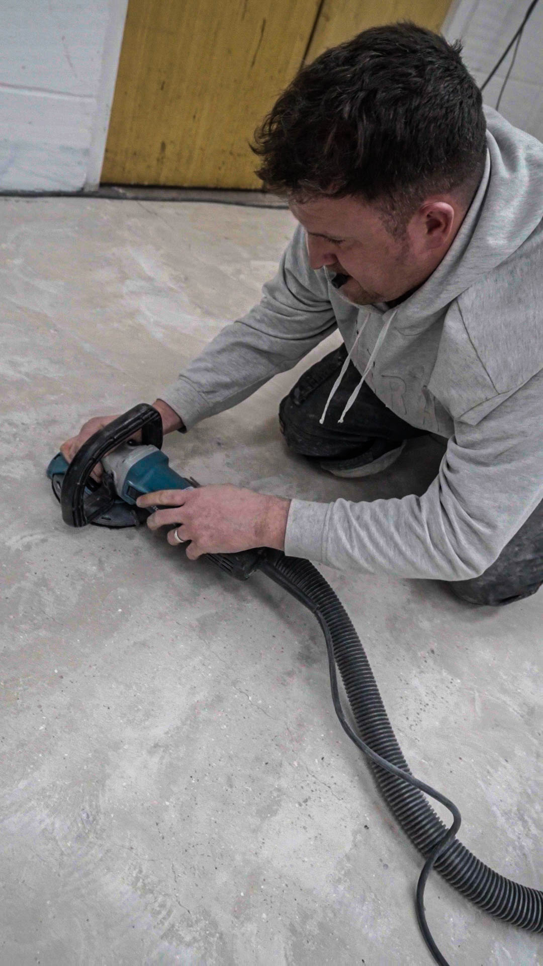 hand grinding concrete floor edges with angle grinder for resin preparation
